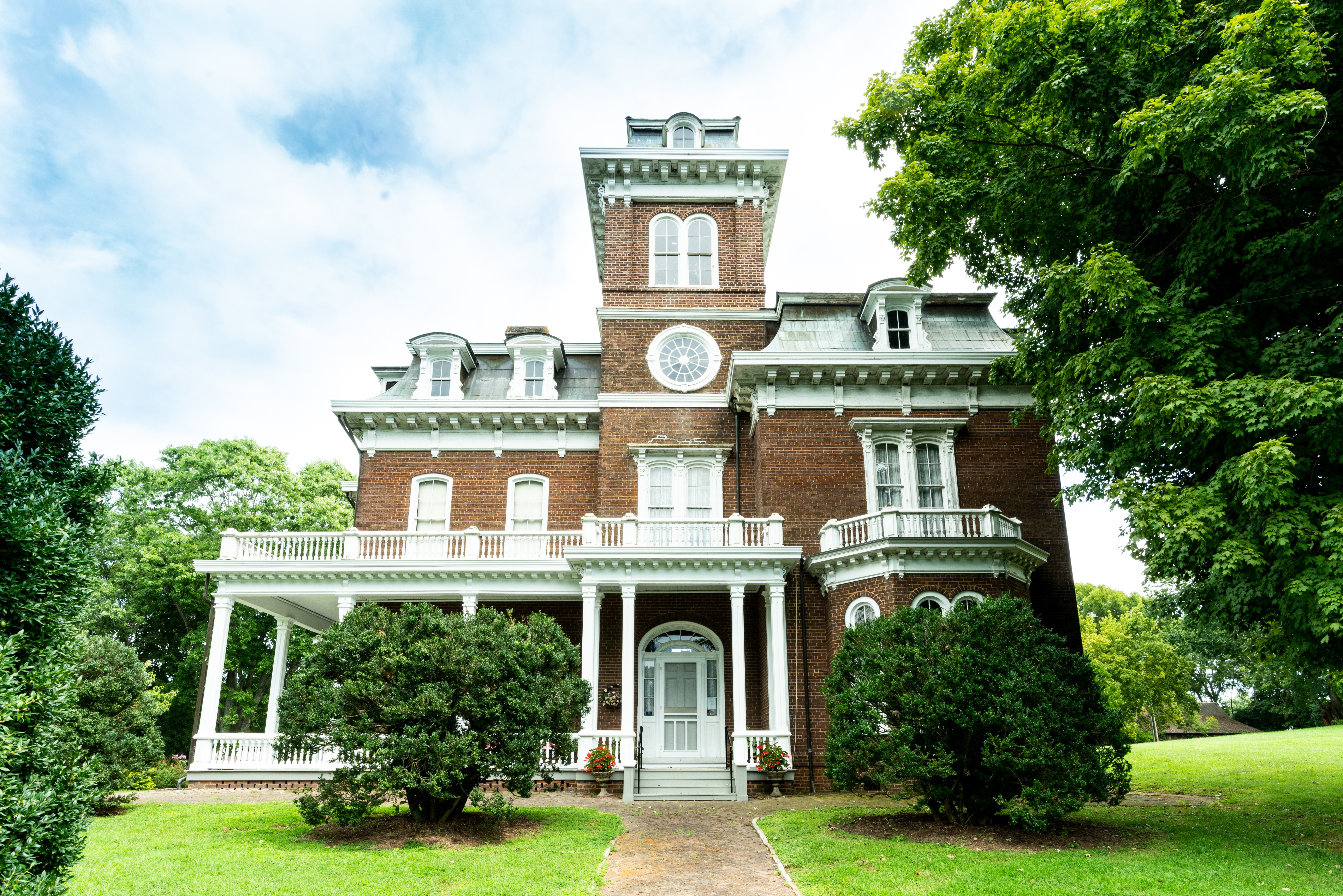 Victorian Mansion home surrounded by trees and grass