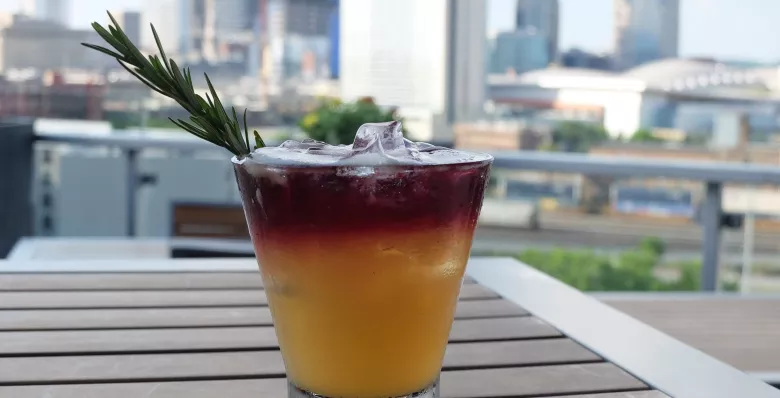 A cocktail at UP Rooftop Lounge with a Nashville skyline view