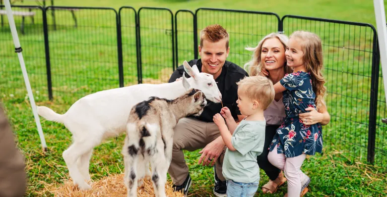 Family meeting a resident goat at Noble Dairy Farm
