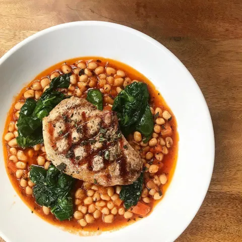 Bean soup with chicken and greens atop