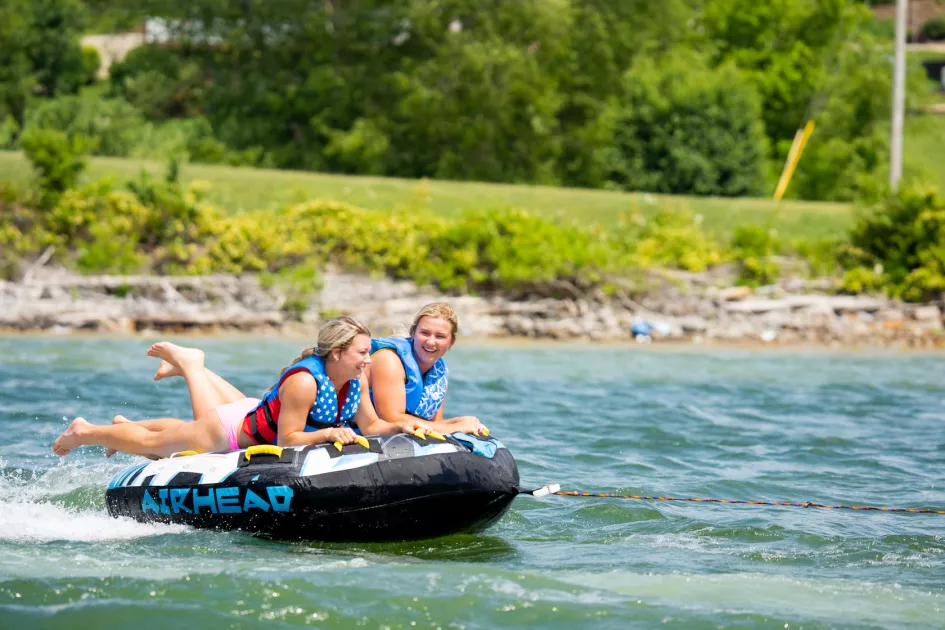 girls riding inner tube on lake