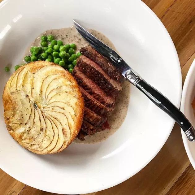 Sliced meat with peas and scalloped potatoes